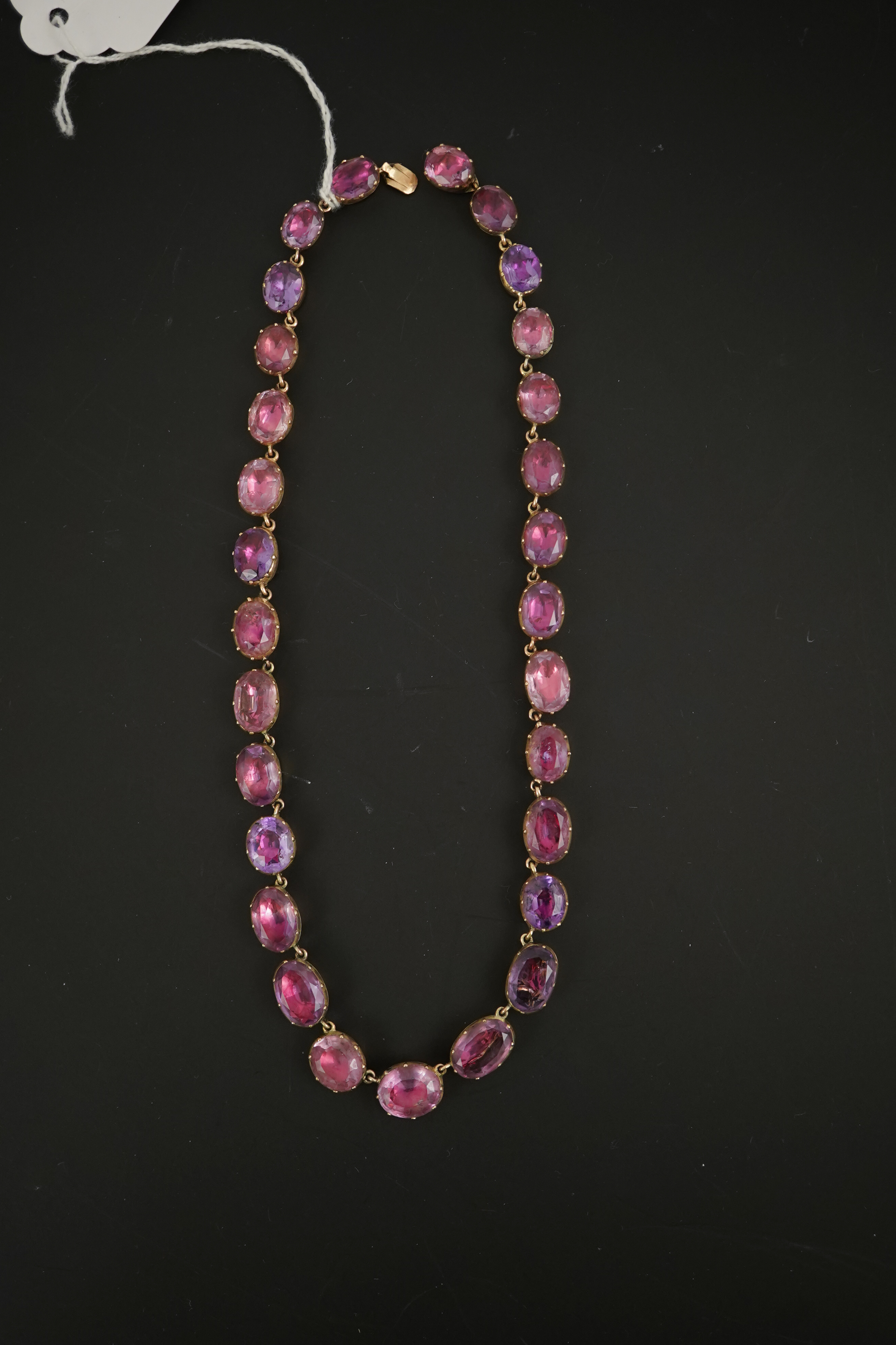 A 19th century gold and graduated oval cut foil backed amethyst or rock crystal set riviere necklace